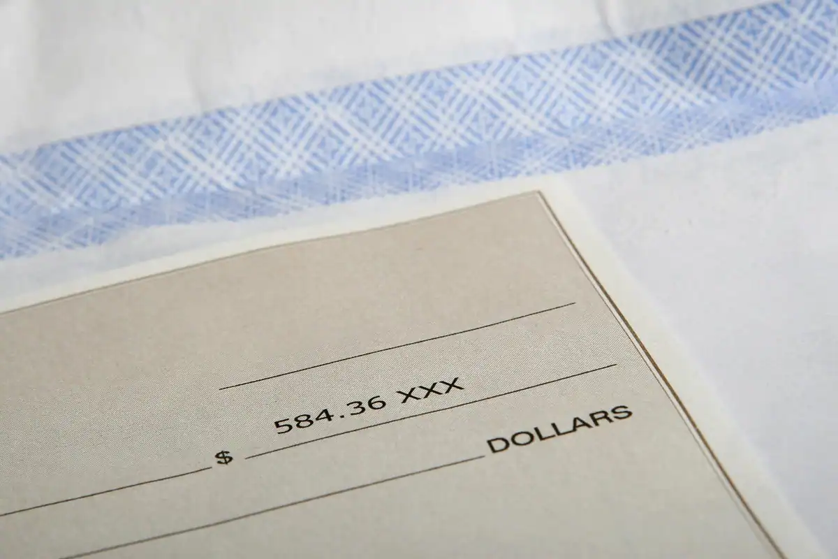 Plic cu salariul și un caiet pe masă, pentru stabilirea procentului economisit lunar