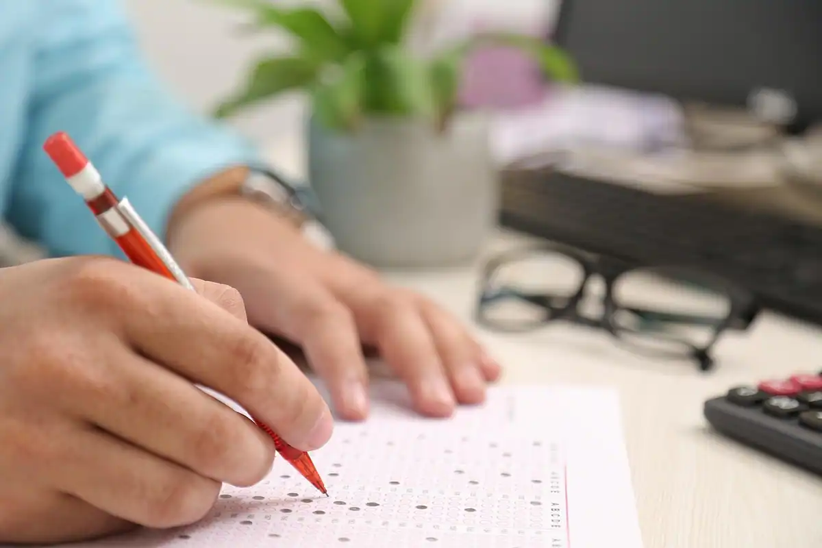 Formulare pe hârtie și un calculator pe birou, pentru calculul impozitului pe locuință