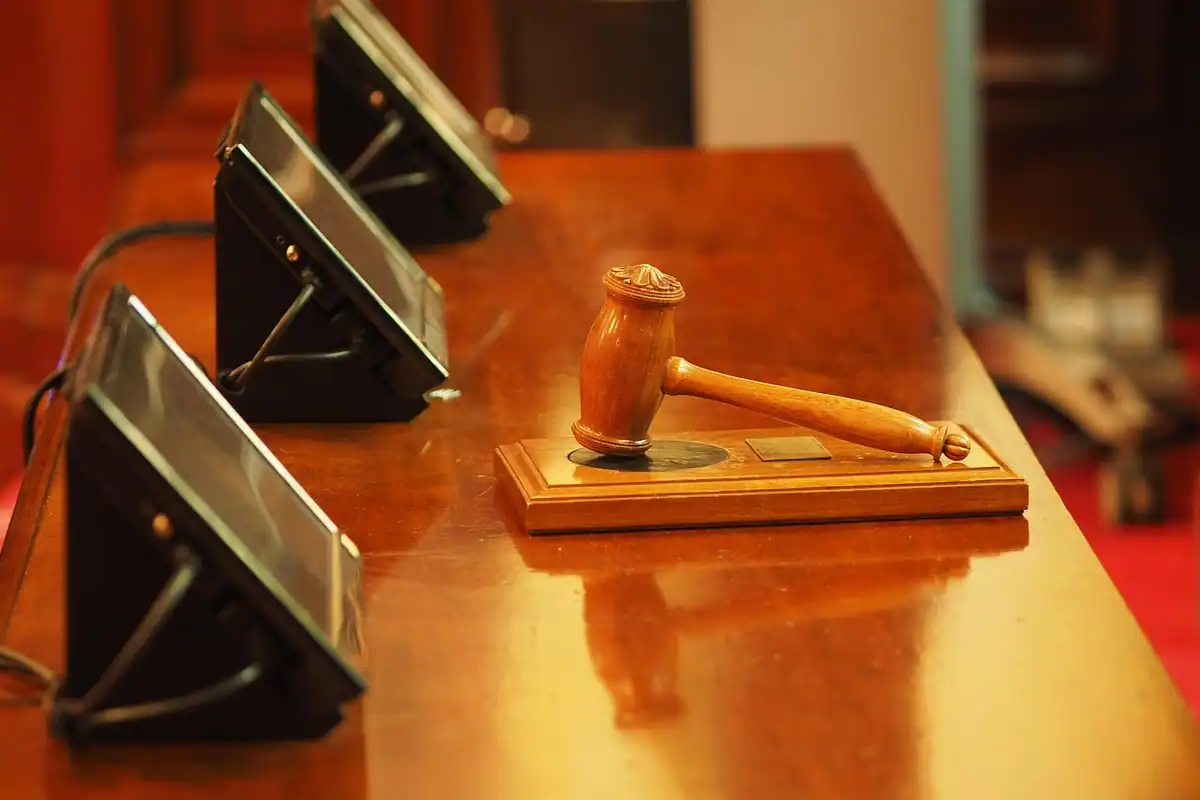 Ciocan de lemn de judecător pe un birou lucios din sala unui tribunal